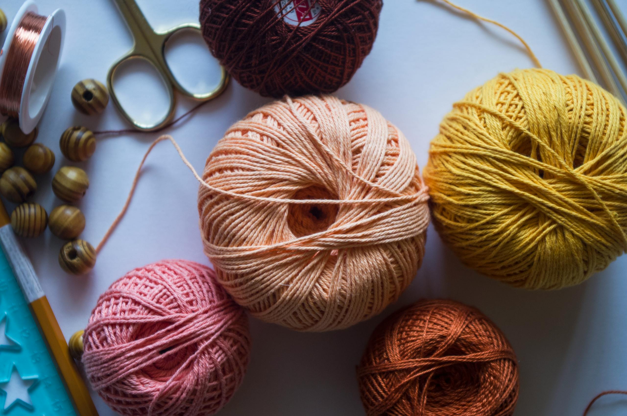 Colorful yarn balls with crafting tools perfect for knitting or DIY projects.